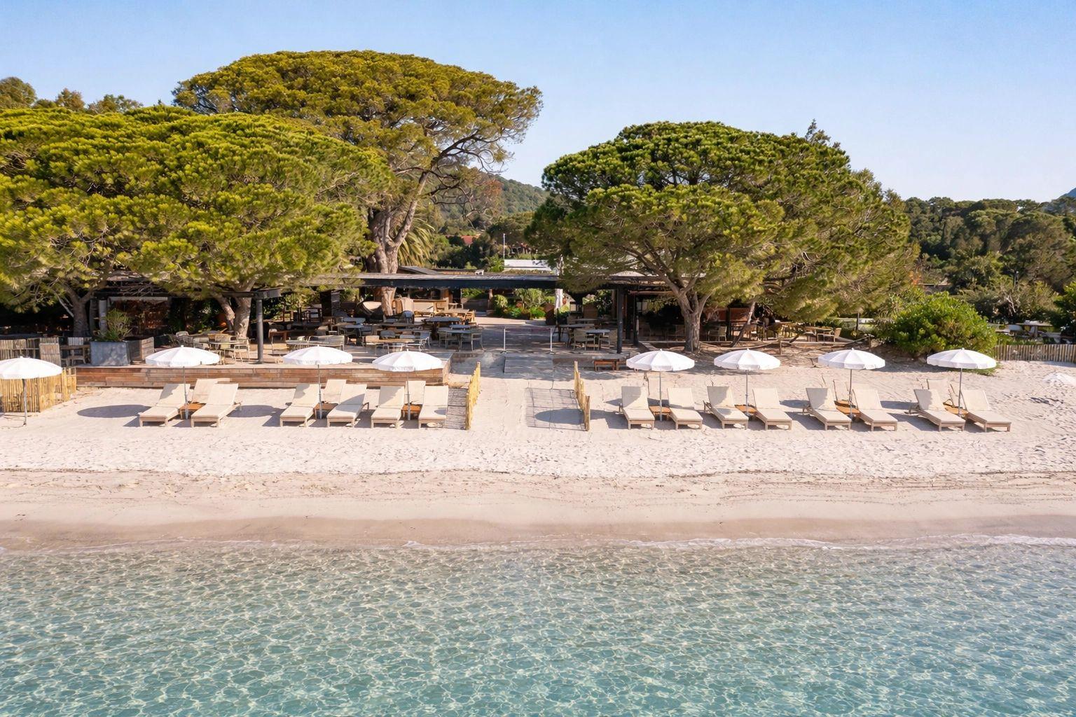 Restaurant de plage à Santa Giulia avec transats et parasols face à la mer turquoise