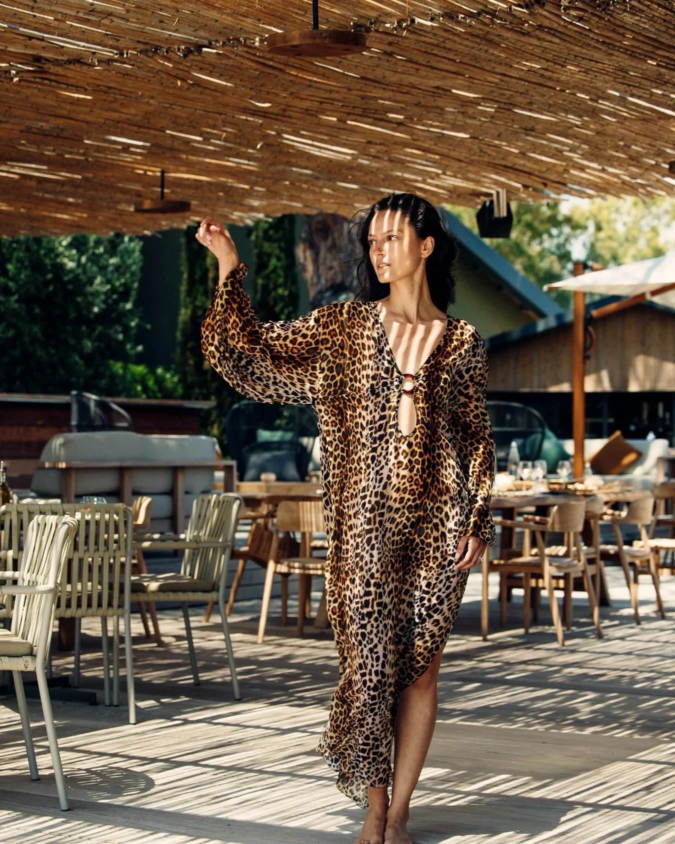 Femme en robe léopard aux accessoires de plage à Santa Giulia