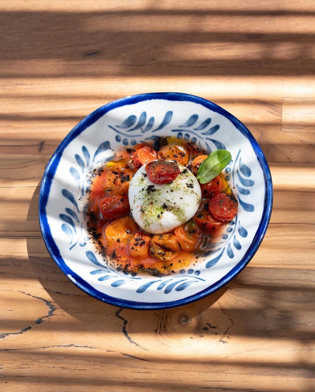 Burrata et tomates rôties sur la carte du restaurant de plage à Santa Giulia