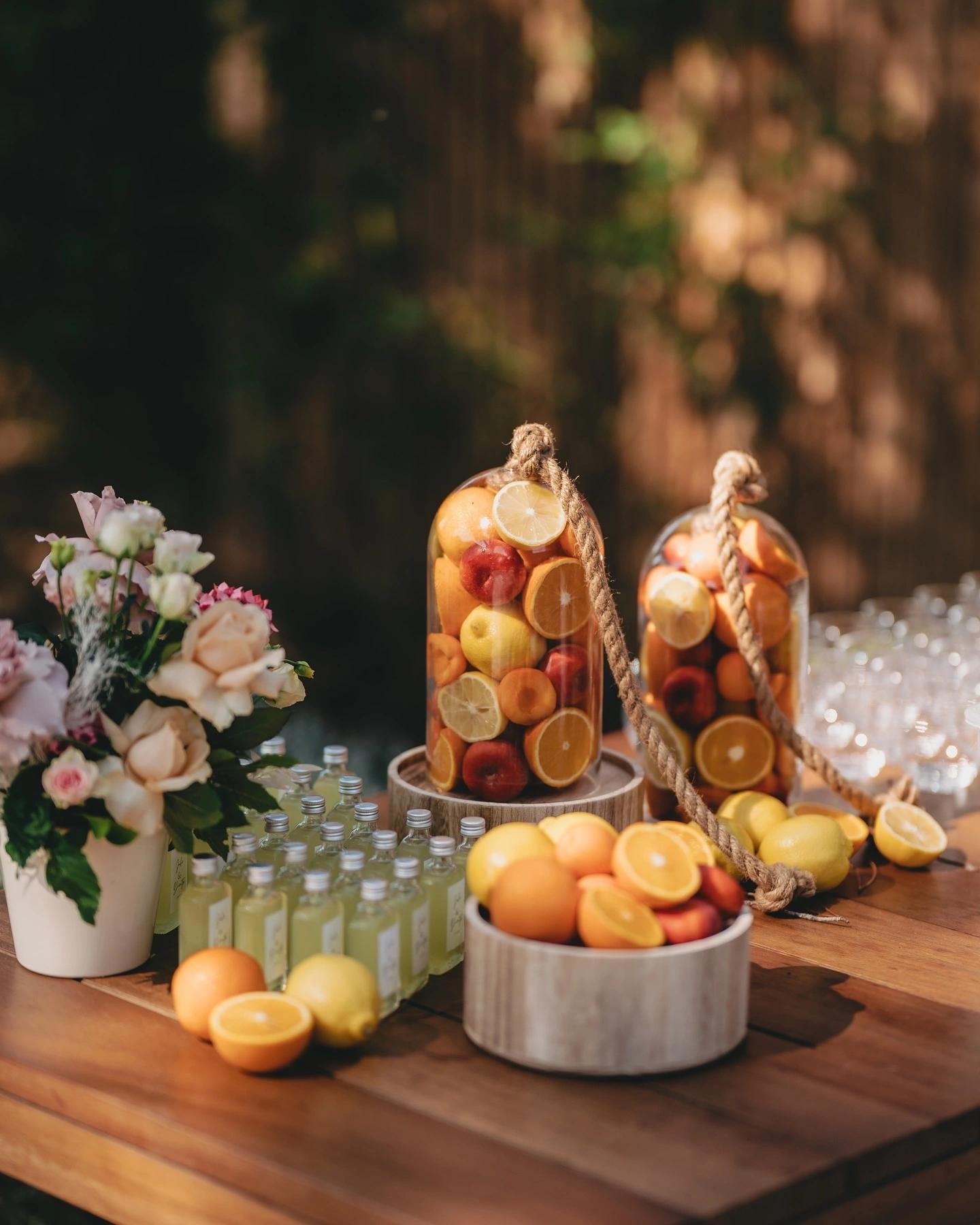 La décoration de table avec agrumes, fleurs et bouteilles pour la carte du restaurant de plage à Santa Giulia