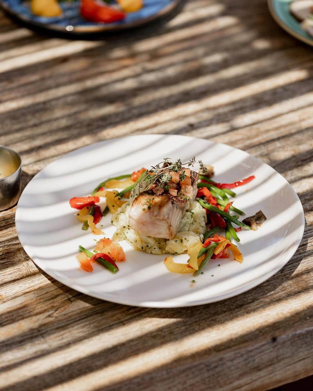 Plat de poisson grillé avec légumes de la carte du restaurant de plage à Santa Giulia