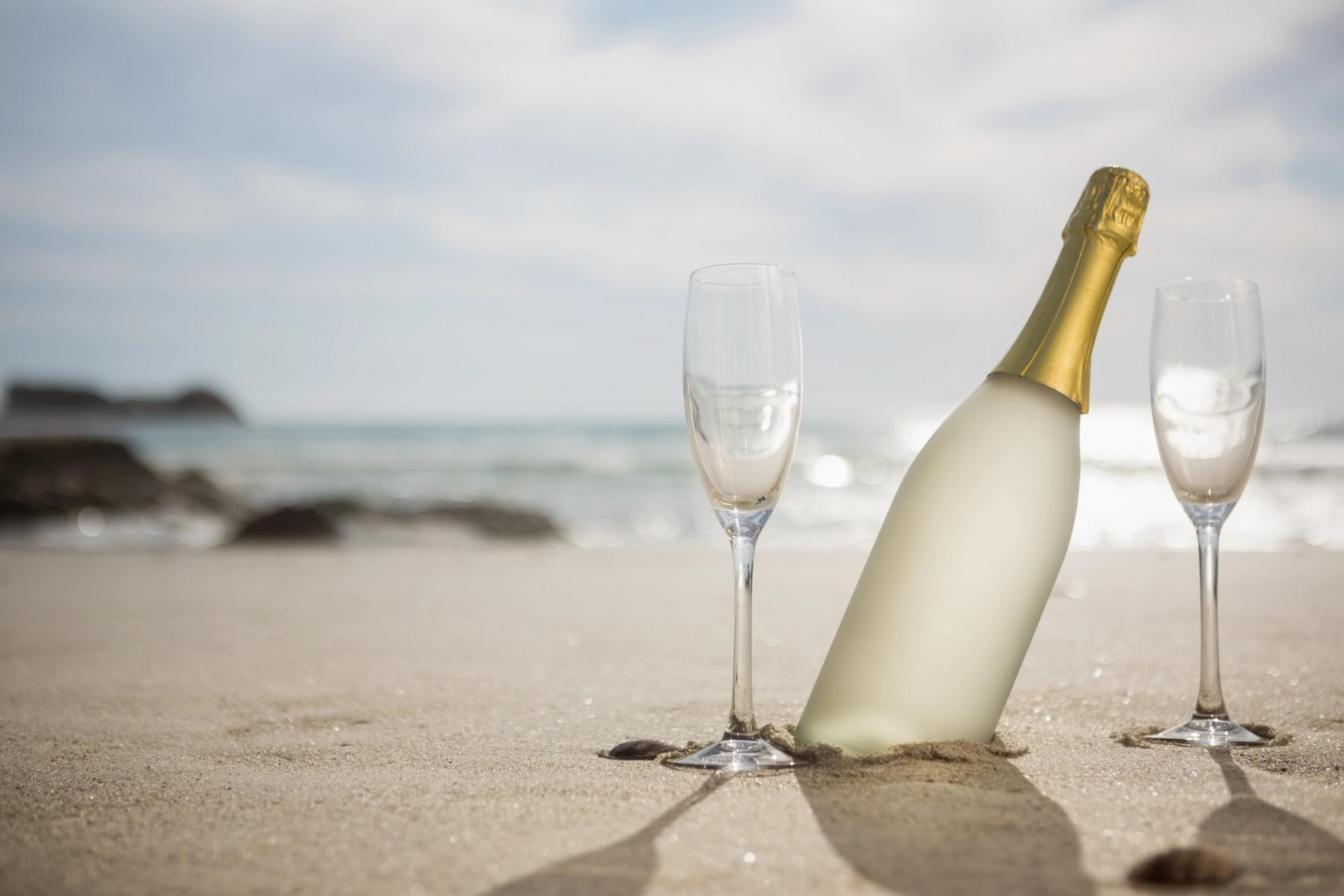 Bouteille de champagne et flûtes sur la plage de Santa Giulia pour célébrer