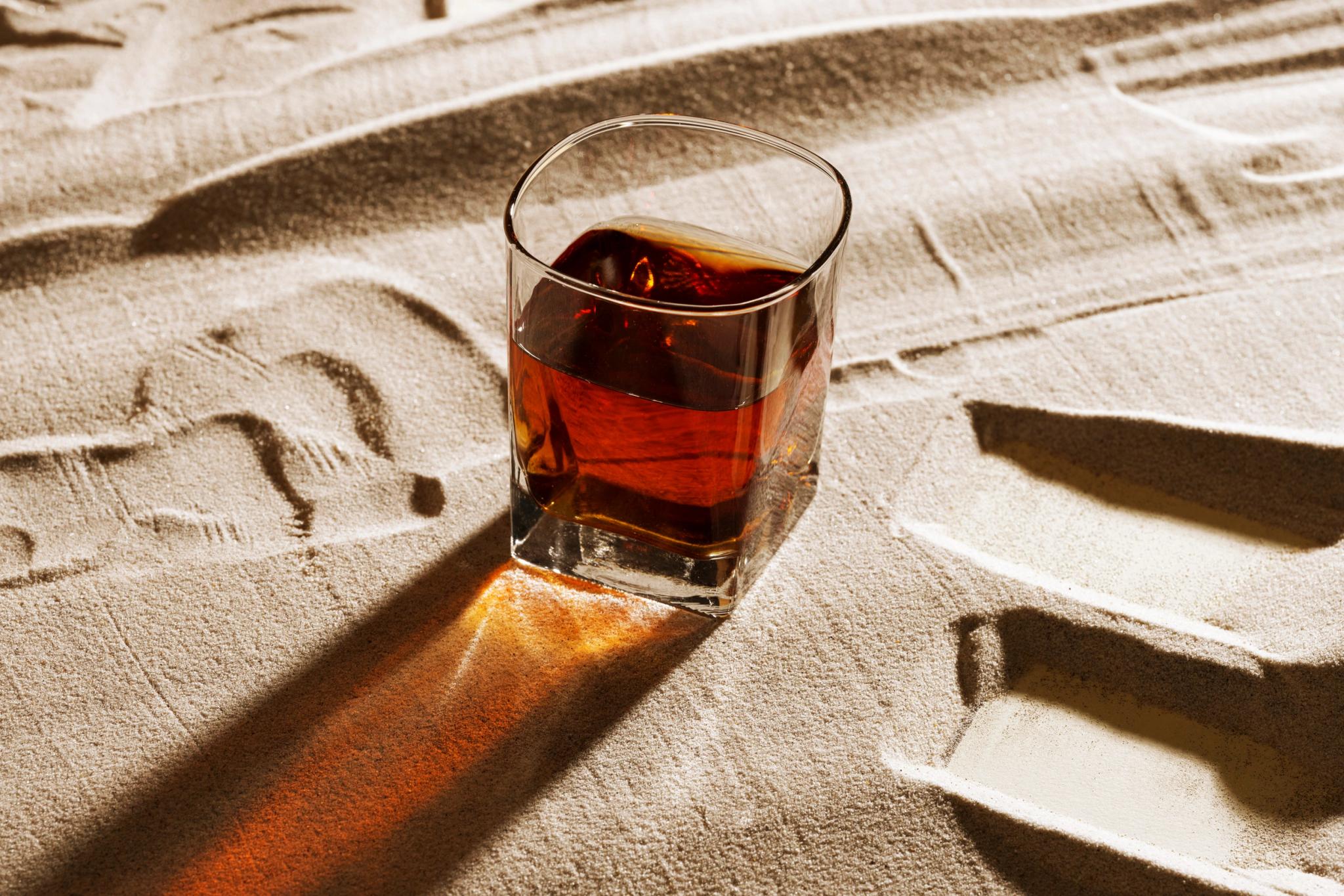 Verre de whisky sur le sable de la plage Santa Giulia restaurant